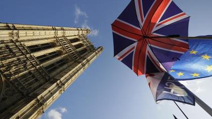 Flags and an umbrella are tied to raiings opposite Britain's parliament buildings in London, Tuesday, Oct. 22, 2019.