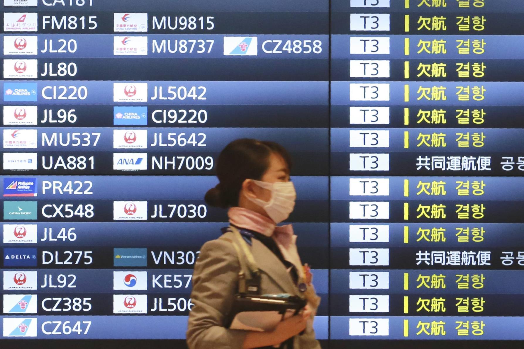 A woman walks through Haneda Internatio<em></em>nal Airport in Tokyo. | AP